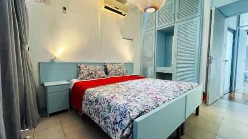 ein kleines Schlafzimmer mit einem Bett mit einer roten Decke in der Unterkunft 3 bedrooms house with terrace and wifi at Trou aux Biches in Trou aux Biches