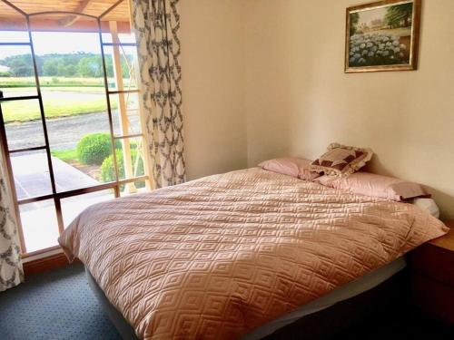 a bedroom with a bed and a window with a view at Old Entally Farm in Hadspen