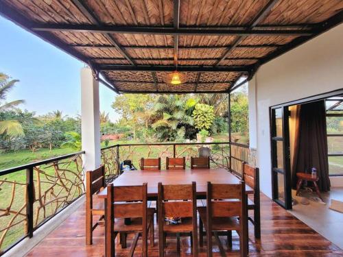 una sala da pranzo con tavolo e sedie su un balcone di Cozy Cabin Casita Anahaw a Indang