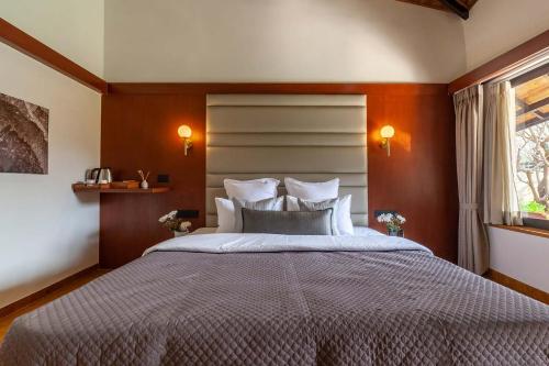 a bedroom with a large bed and a window at StayVista's Lush Villa - Rustic-Meets-Modern Interiors, Pool, Jacuzzi & Indoor activities in Wādhiware