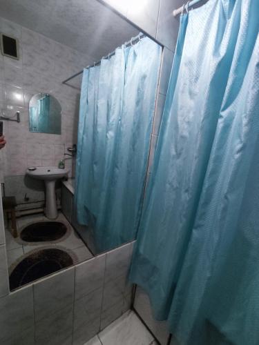 baño con ducha con cortina azul en X.ata 3 en Almaty