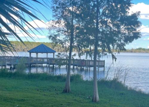 a dock with a gazebo next to a lake at Disney 1 mile , Blue Heron 1 room 2 bath,amenities,6 guests, walk to restaurants, no fees at check in in Orlando