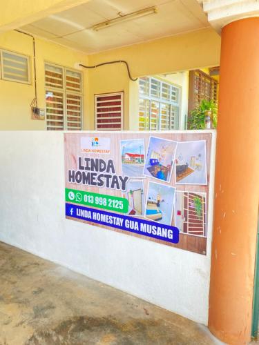 a sign on a wall in front of a house at LH Homestay Bandar Utama Gua Musang in Gua Musang