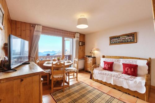 1 dormitorio con cama, mesa y ventana en Edelweiss De Cordon - Happy Rentals en Cordon