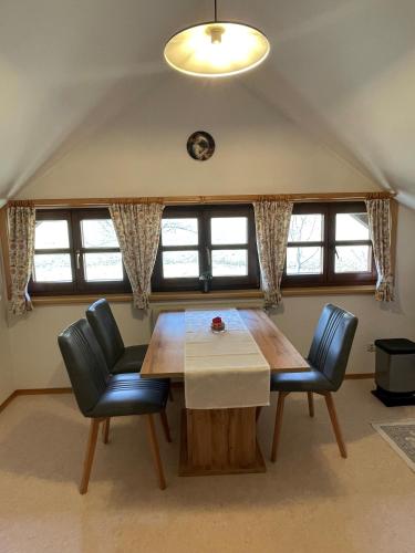 a dining room with a wooden table and two chairs at Ferienwohnung Syen in Grundlsee