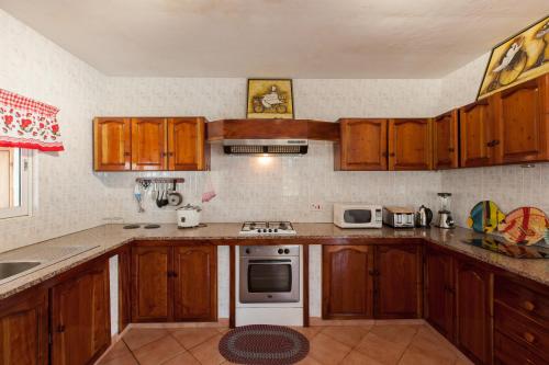 a kitchen with wooden cabinets and a white stove top oven at Villa Aya in Grand'Anse Praslin