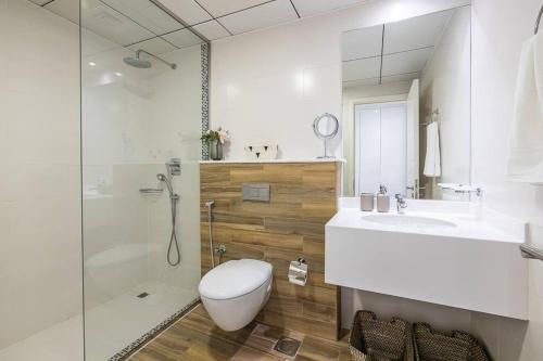 a bathroom with a toilet and a sink and a shower at Unique Cosy &Spacious 2BR In Al Sufouh in Dubai