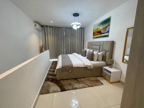 a bedroom with a large bed and a mirror at The Lennox Luxury Suites & Apartments in Accra