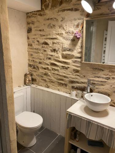 ein Badezimmer mit einem weißen WC und einem Waschbecken in der Unterkunft La Glycine in Landévant