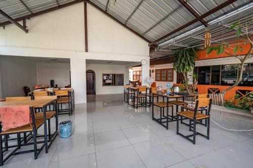 an empty restaurant with wooden tables and chairs at Noble Thippanate in Chiang Mai