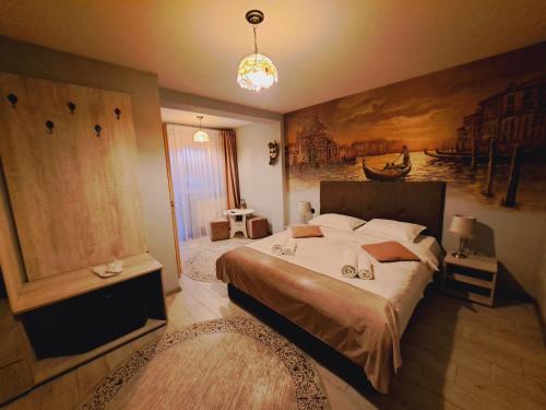 1 dormitorio con 1 cama y una pintura en la pared en VILLA BEL CANTO, en Cristian