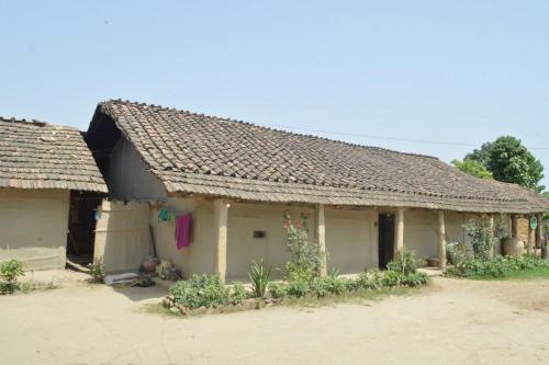 una casa antigua con techo de baldosa en un pueblo en Bhada Community Homestay, 