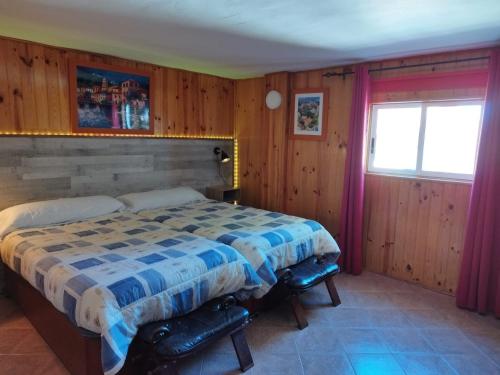 una camera con un letto in una stanza con pareti in legno di Casa LLANO43 Lago & Montaña a Las Rozas de Valdearroyo