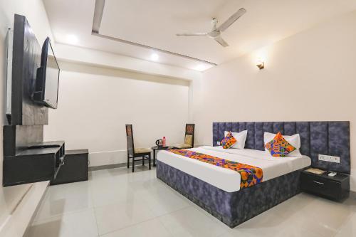 um quarto com uma cama e uma televisão de ecrã plano em FabHotel Silver Stone Inn em Lucknow