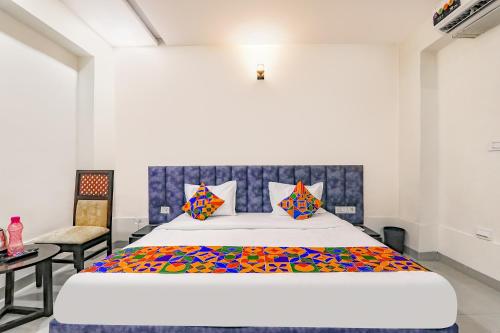 um quarto com uma cama grande e uma cadeira em FabHotel Silver Stone Inn em Lucknow