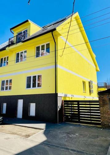 un edificio amarillo y negro con garaje en Lemon Premium Apartment, en Szeged