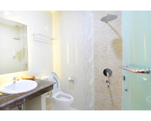 y baño con aseo, lavabo y ducha. en Emerald Hotel en Ternate