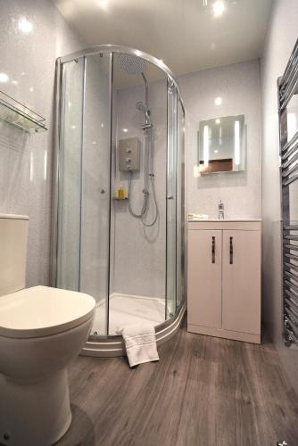 a bathroom with a shower with a toilet and a sink at Balcarres Bed and Breakfast in Fort William