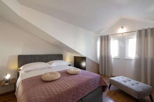 una camera con un letto con due cuscini sopra di PENTHOUSE J&A a Vela Luka (Vallegrande)