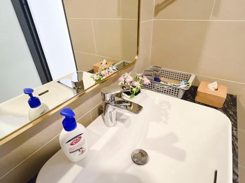 a bathroom sink with a bottle of soap and a mirror at Lam's Beach Homestay in Phan Thiet