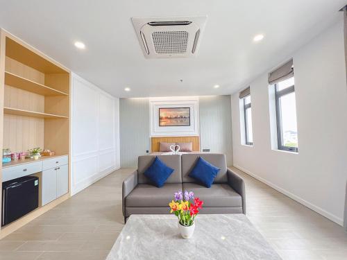 a living room with a couch and a table with flowers at Lam's Beach Homestay in Phan Thiet