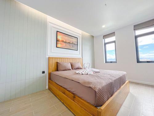 a bedroom with a bed and two windows at Lam's Beach Homestay in Phan Thiet