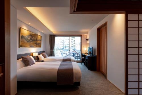 京都的住宿－Rinn Gion Hanatouro，酒店客房设有两张床和窗户。