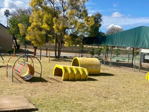 a playground with yellow play equipment in a park at 86 Pendleberry Holiday Grove in Warmbaths