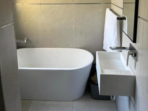a white bath tub and a sink in a bathroom at 86 Pendleberry Holiday Grove in Warmbaths