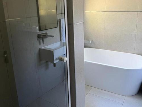 a bathroom with a shower and a sink and a tub at 86 Pendleberry Holiday Grove in Warmbaths