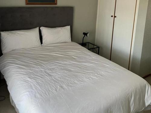 a bed with white sheets and pillows in a room at 86 Pendleberry Holiday Grove in Warmbaths
