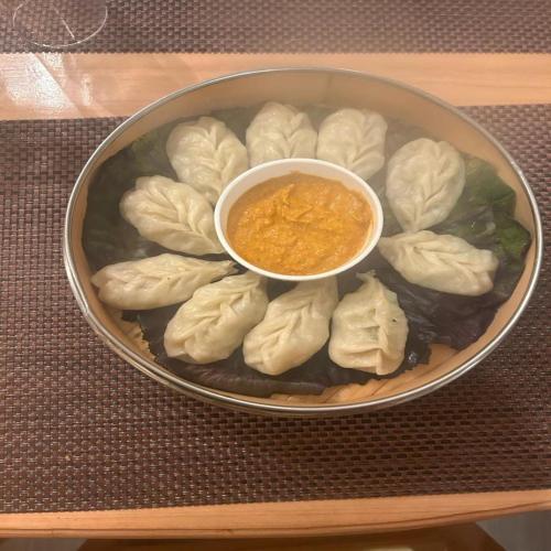 a bowl of dumplings with a bowl of dipping sauce at Amaira Resort & Farms - Mirik, West Bengal in Mirik