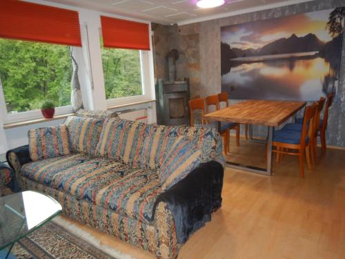 ein Wohnzimmer mit einem Sofa und einem Tisch in der Unterkunft Pension Pulvermühle in Waischenfeld