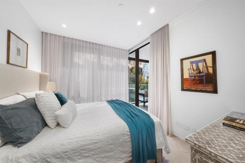 a white bedroom with a bed and a large window at HARR85TR - Harrington on the Harbour in Sydney