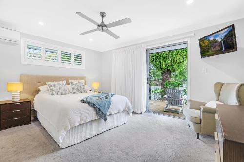 a white bedroom with a bed and a sliding glass door at Chic Miami 4BR Retreat with Swimming Pool & BBQ in Gold Coast