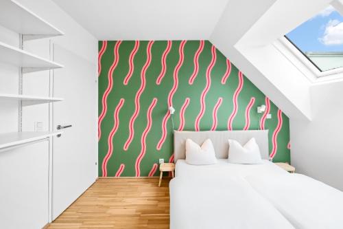 um quarto com uma cama e uma parede verde e branca em Arbio I Ding Design Apartments in Brigittenau Vienna em Viena