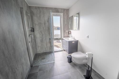 uma casa de banho com um chuveiro, um WC e um lavatório. em Runde Panorama - Trollvogga em Runde