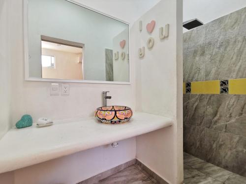 y baño con lavabo y espejo. en Hostel Humanity, en Puerto Morelos