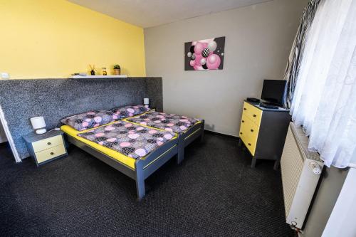 a small bedroom with a bed and a dresser at Penzion U Tulaka in Dobřichovice