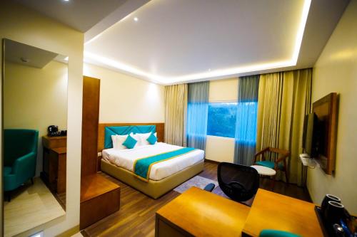 a hotel room with a bed and a desk at Quality Inn Rockwell Grand, Bangalore in Bengaluru