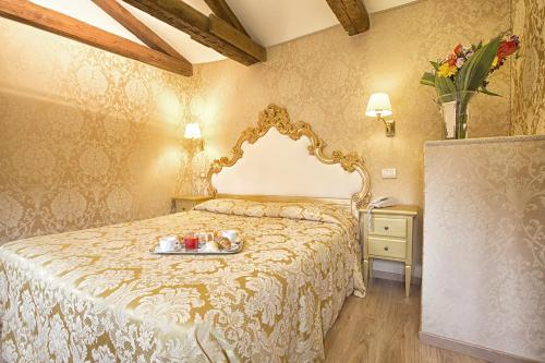 a hotel room with a bed and a dresser at Residenza Goldoni in Venice