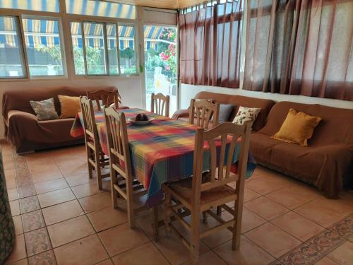 sala de estar con mesa, sillas y sofá en ALOJAMIENTO RURAL CEREZO, en Murcia