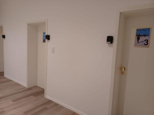 a hallway with white walls and wooden floors at CITYLIFE Apartments Economy Osnabrück in Osnabrück