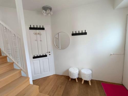 a room with a staircase with a mirror and stools at Haus Grünfels ApARTment in Murau