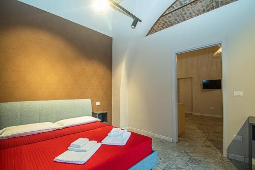 Un dormitorio con una cama roja con toallas. en suebi appartament and rooms, en Termoli