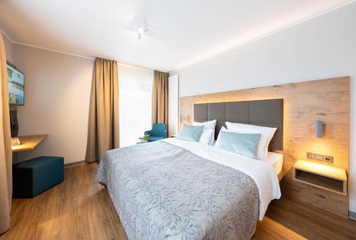 a hotel room with a large bed with blue pillows at Sopherl am See - Frühstück auf der Seeterrasse, sehr ruhig und wunderschön am See, 3 Minuten nach Oberpfaffenhofen, viele Radtouren, Restaurants & Cafes in der Umgebung in Weßling