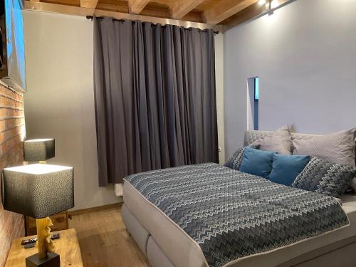 a bedroom with a bed with blue pillows and a window at Spreewaldhaus Widwan in Lübbenau