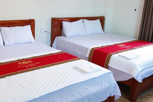 twee bedden naast elkaar in een kamer bij Biển Hải Tiến - Nhà nghỉ Ngân Khánh in Thanh Hóa