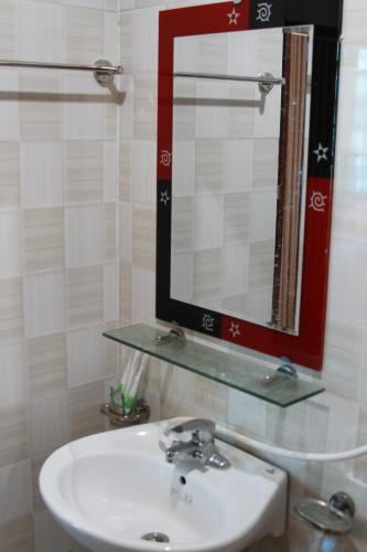 ein Bad mit einem Waschbecken und einem Spiegel in der Unterkunft Biển Hải Tiến - Nhà nghỉ Ngân Khánh in Thanh Hóa