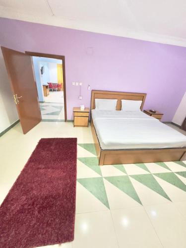 a bedroom with a bed and a red rug at Golden Quba 1 in Riyadh